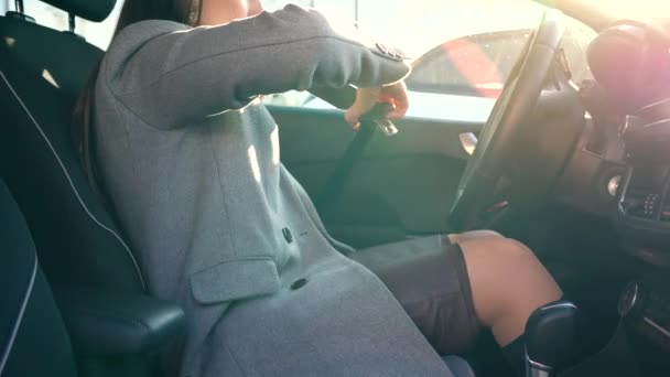 Kvinna infästning bil säkerhet säkerhetsbältet när du sitter inne i fordonet innan körning — Stockvideo