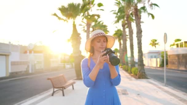 Fotógrafa turista tomando fotos con cámara en un hermoso paisaje tropical al atardecer — Vídeos de Stock