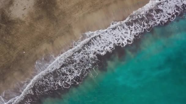 大西洋上の砂漠のビーチのトップビュー。テネリフェ島の海岸。海岸に到達する海の波の空中ドローン映像 — ストック動画
