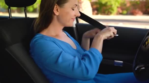 Vrouw die auto veiligheidsgordel bevestiging zittend binnenkant voertuig vóór het rijden — Stockvideo