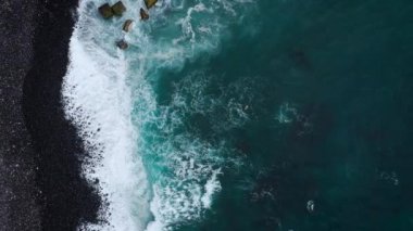 Atlas Okyanusu'ndaki ıssız siyah volkanik plajın en iyi manzarası. Tenerife adasının sahili. Kıyıya ulaşan deniz dalgalarının havadan drone görüntüleri
