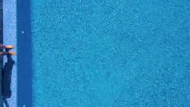 Bir adam havuzun kenarında duruyor gibi yukarıdan görünümü, dalış ve su altında yüzer — Stok video