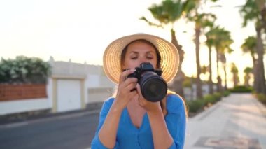 Fotoğrafçı turist kadın gün batımında güzel bir tropikal manzara kamera ile fotoğraf çekmek