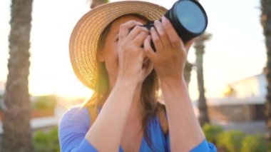 Fotoğrafçı turist kadın gün batımında güzel bir tropikal manzara kamera ile fotoğraf çekmek