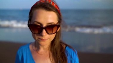 Siyah bir volkanik plajda güzel mavi elbiseli bir kadının portresi. Farklı hızlarda filme - hızlandırılmış ve normal