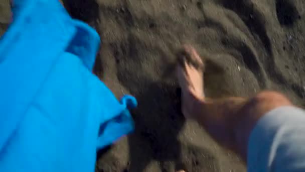 Top view of couple strolling together at the black volcanic sand at ocean beach — Stock Video