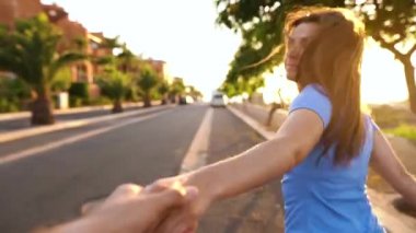 Beni takip edin - mutlu genç kadın erkekler el çekerek - parlak güneşli bir günde çalışan el ele