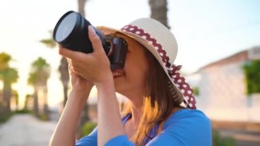 Fotoğrafçı turist kadın gün batımında güzel bir tropikal manzara kamera ile fotoğraf çekmek