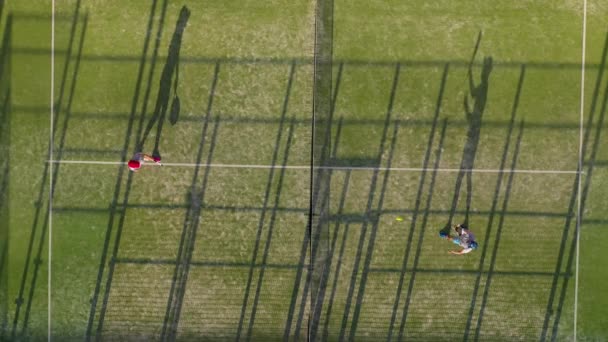 Vista desde la altura de la pista de tenis donde la gente juega en el tenis — Vídeos de Stock