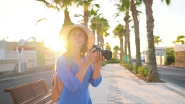 Fotoğrafçı turist kadın gün batımında güzel bir tropikal manzara kamera ile fotoğraf çekmek