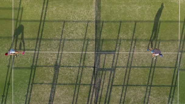 Widok z wysokości kortu tenisowego, gdzie ludzie rozgrzewą się przed grą — Wideo stockowe