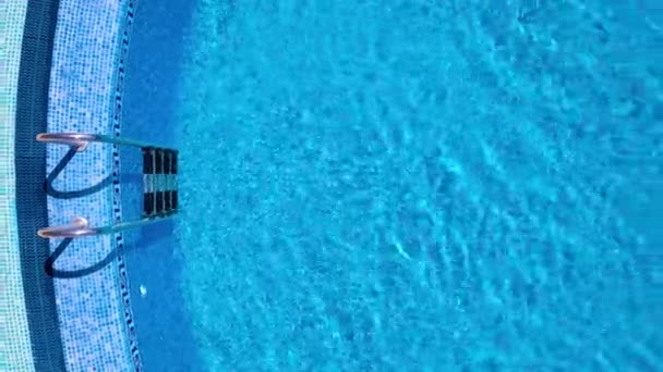 Pohled shora z dronu přes žebřík a povrch bazénu — Stock video