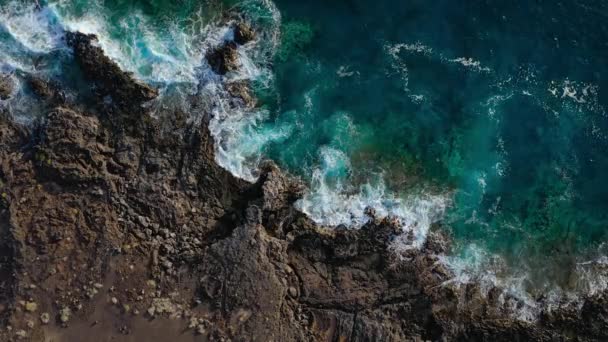 Egy elhagyatott part első látásra. Tenerife szigetének sziklás partja. Légi felvételek a partot elérő tengeri hullámokról — Stock videók