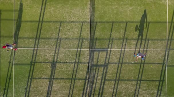 Вид с высоты теннисного корта, где люди разминаются перед игрой — стоковое видео