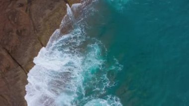 Atlas Okyanusu'ndaki çöl taşlı sahilinin en iyi manzarası. Tenerife adasının sahili. Kıyıya ulaşan deniz dalgalarının havadan drone görüntüleri