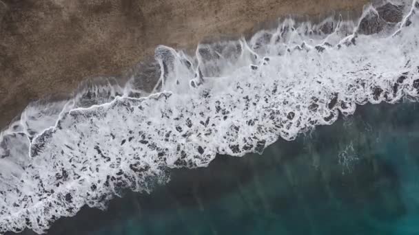 大西洋の砂漠の黒いビーチのトップビュー。テネリフェ島の海岸。海岸に到達する海の波の空中ドローン映像 — ストック動画