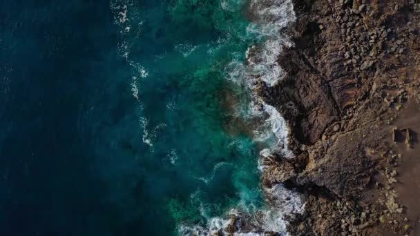 Vista superior de una costa desierta. Orilla rocosa de la isla de Tenerife. Imágenes aéreas de drones de olas marinas que llegan a la orilla — Vídeo de stock