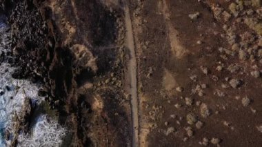 Kadının havadan görünümü gün doğumunda okyanus kıyısındaki doğa rezervi boyunca uzanır. Sağlıklı aktif yaşam tarzı
