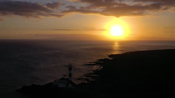 Kilátás a magassága a világítótorony sziluett Faro de Rasca naplementekor a Tenerife, Kanári-szigetek, Spanyolország. Az Atlanti-óceán vad partja — Stock videók