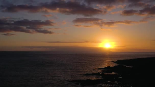 Luchtfoto van de Atlantische Oceaan en de rotsachtige kust op de achtergrond van een prachtige zonsondergang — Stockvideo