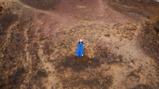 Veduta aerea della donna in un bellissimo vestito blu e cappello si trova sulla cima di una montagna in una zona di conservazione sulle rive dell'Oceano Atlantico. Tenerife, Isole Canarie, Spagna — Video Stock