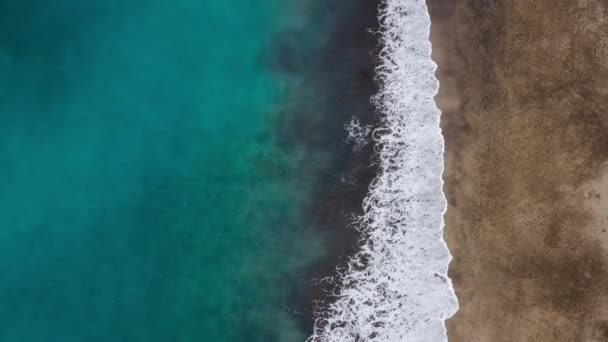 Blick von oben auf den schwarzen Wüstenstrand am Atlantik. Küste der Insel Teneriffa. Drohnenaufnahmen von Meereswellen, die die Küste erreichen — Stockvideo