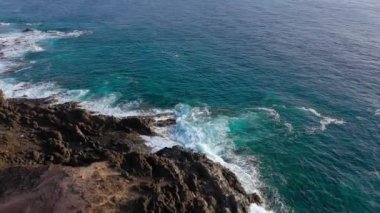 Issız bir sahilin zirvesinden manzara. Tenerife adasının kayalık kıyısı. Kıyıya ulaşan deniz dalgalarının havadan drone görüntüleri
