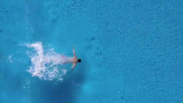 Vista dall'alto mentre un uomo si tuffa nella piscina e nuota sott'acqua — Video Stock