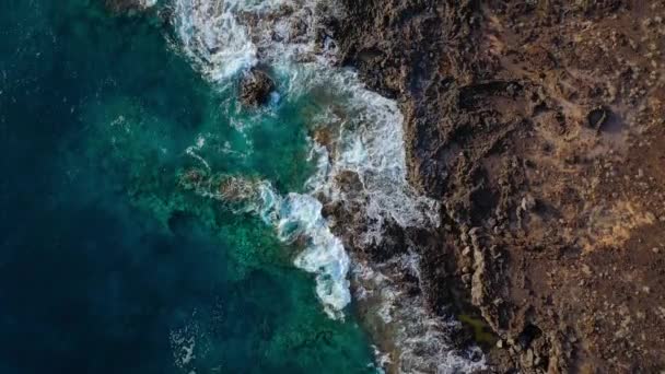 황량 한 해안의 맨 위에 있는 풍경. 테네리페 섬의 로키 해변. 해안에 도달하는 바 다 물결의 공중 드론 영상 — 비디오