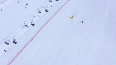 Kayak pisti - telesiyej, kayakçılar ve snowboardcular aşağı gidiyor. Havadan görünüm