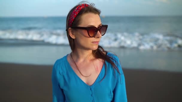Siyah bir volkanik plajda güzel mavi elbiseli bir kadının portresi. Yavaş çekim — Stok video
