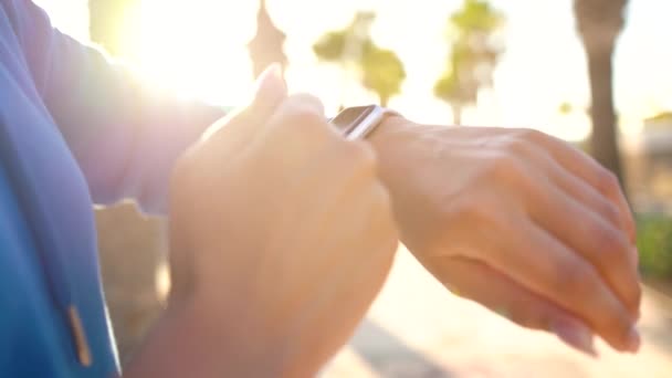 Un reloj inteligente. Mujer usando reloj inteligente. Primer plano de la pantalla táctil táctil femenina en el reloj, entrar en la aplicación de reloj y comienza a correr — Vídeo de stock