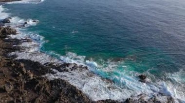 Issız bir sahilin zirvesinden manzara. Tenerife adasının kayalık kıyısı. Kıyıya ulaşan deniz dalgalarının havadan drone görüntüleri