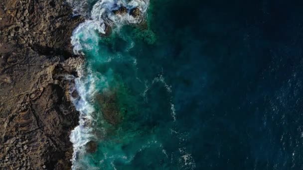 Bovenaanzicht op een verlaten kust. Rotsachtige kust van het eiland Tenerife. Luchtdrone beelden van zeegolven die de kust bereiken. — Stockvideo