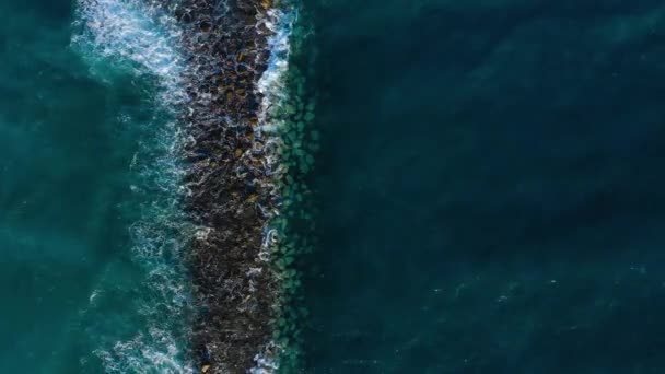 Blick von oben auf die Oberfläche des Atlantiks in Küstennähe - Wellen rollen durch die Buhne. Küste der Insel Teneriffa — Stockvideo