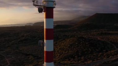 Tenerife, Kanarya Adaları, İspanya gün batımında deniz feneri Faro de Rasca, doğa rezerv ve karanlık bulutların yüksekliği görünümü. Atlantik Okyanusu'nun vahşi sahili. Hızlandırılmış video