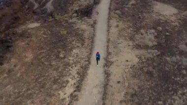 Gün doğumunda doğa rezervi boyunca koşan bir kadının havadan görünümü. Sağlıklı aktif yaşam tarzı.