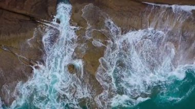 Atlas Okyanusu'ndaki çöl taşlı sahilinin en iyi manzarası. Tenerife adasının sahili. Kıyıya ulaşan deniz dalgalarının havadan drone görüntüleri