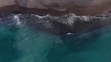 Atlantik Okyanusu'ndaki çöl siyah plajının en iyi manzarası. Tenerife adasının sahili. Kıyıya ulaşan deniz dalgalarının havadan drone görüntüleri