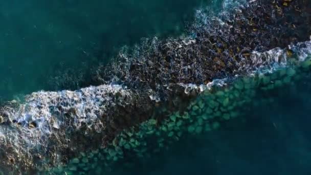 Vista dall'alto della superficie dell'Oceano Atlantico vicino alla costa - onde rotolano attraverso il frangiflutti. Costa dell'isola di Tenerife — Video Stock