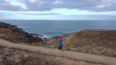 Gün doğumunda doğa rezervi boyunca koşan bir kadının havadan görünümü. Sağlıklı aktif yaşam tarzı