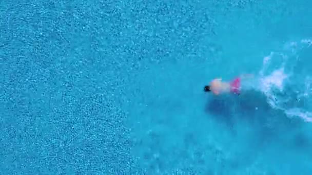 Utsikt från toppen som en man dyk i poolen och simmar vattnet — Stockvideo