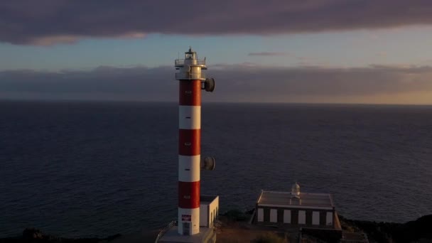 Tenerife, Kanarya Adaları, İspanya gün batımında deniz feneri Faro de Rasca, doğa rezerv ve karanlık bulutların yüksekliği görünümü. Atlantik Okyanusu'nun Vahşi Kıyısı — Stok video