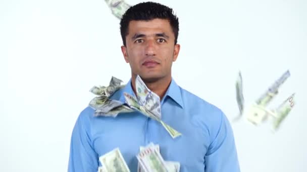 Movimento lento do homem árabe em pé sobre um fundo branco, e um monte de notas de dólar são repentinamente jogados nele de lados diferentes — Vídeo de Stock