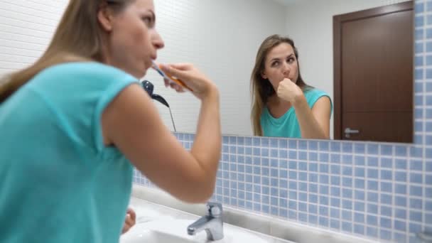 Hübsche Frau beim morgendlichen Zähneputzen im Badezimmer. Morgenhygiene. — Stockvideo