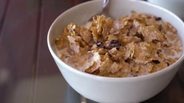 Lezzetli kahvaltı - kaşık süt ile bir kase çikolata parçaları ile mısır gevreği karıştırın. Yavaş çekim