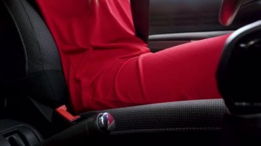 Kırmızı elbiseli kadın sürüş den önce aracın içinde otururken araba emniyet kemeri bağlama
