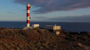 Tenerife, Kanarya Adaları, İspanya gün batımında deniz feneri Faro de Rasca, doğa rezerv ve karanlık bulutların yüksekliği görünümü. Atlantik Okyanusu'nun Vahşi Kıyısı