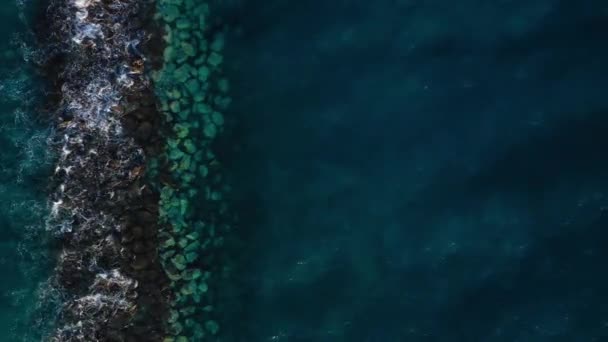 Vista superior da superfície do Oceano Atlântico perto da costa - ondas rolam através do quebra-mar. Costa da ilha de Tenerife — Vídeo de Stock