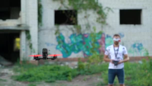 Piloto masculino maneja FPV freestyle drone y hace una voltereta en el aire. Movimiento lento — Vídeo de stock